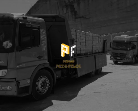 Foto preto e branco de dois caminhões carregados de pedras grês com o logo da Pedras Pai e Filho a frente